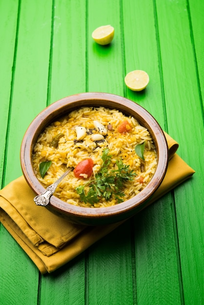 Dal khichadi o Khichdi Sabrosa receta india servida en un tazón sobre un fondo de mal humor está hecha de toovar dal y arroz combinado con especias enteras, cebollas, ajo y tomates, etc. Enfoque selectivo