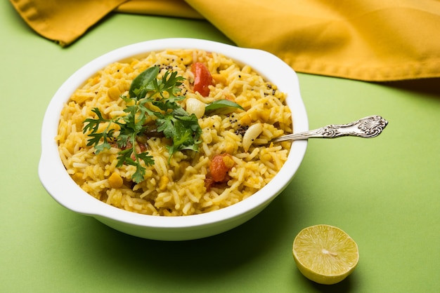 Dal khichadi o Khichdi Sabrosa receta india servida en un tazón sobre un fondo de mal humor está hecha de toovar dal y arroz combinado con especias enteras, cebollas, ajo y tomates, etc. Enfoque selectivo