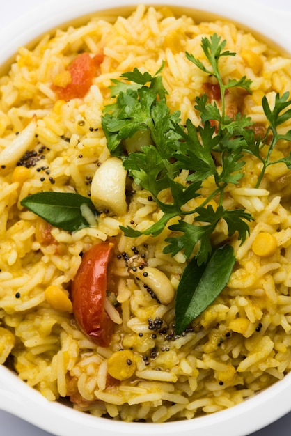 Dal khichadi ou Khichdi Tasty Receita indiana servida em uma tigela sobre um fundo melancólico é feita de toovar dal e arroz combinado com especiarias inteiras, cebola, alho e tomate, etc. Foco seletivo