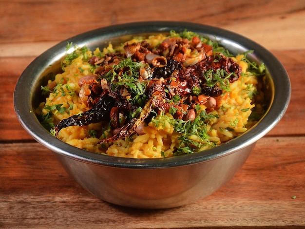 Dal khichdi o Khichadi Sabrosa receta india servida en un tazón sobre fondo rústico de madera La comida hecha de dal y arroz combinado con especias enteras cebollas ajo y tomates, etc. Enfoque selectivo