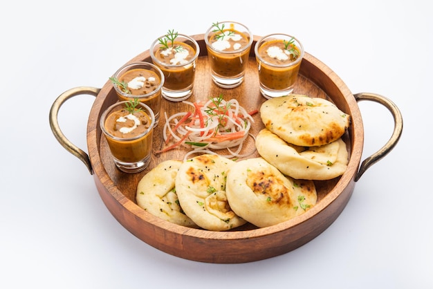 Dal Makhani o dal makhni Tragos con mantequilla y crema de frijoles Naan y servidos con naan de ajo o pan indio o roti