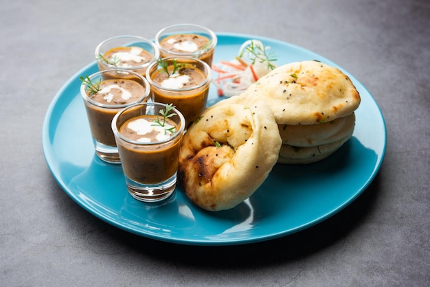 Dal Makhani o dal makhni Tragos con mantequilla y crema de frijoles Naan y servidos con naan de ajo o pan indio o roti