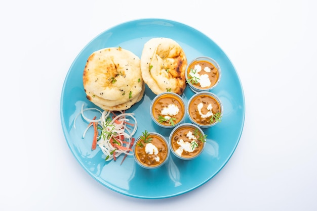 Dal Makhani o dal makhni Tragos con mantequilla y crema de frijoles Naan y servidos con naan de ajo o pan indio o roti