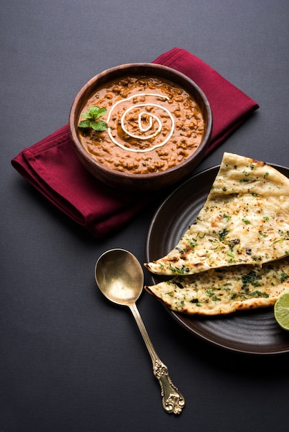 Dal Makhani oder Daal Makhni ist ein beliebtes Essen aus Punjab, Indien, das aus ganzen schwarzen Linsen, roten Kidneybohnen, Butter und Sahne hergestellt und mit Knoblauch-Naan oder indischem Brot oder Roti . serviert wird