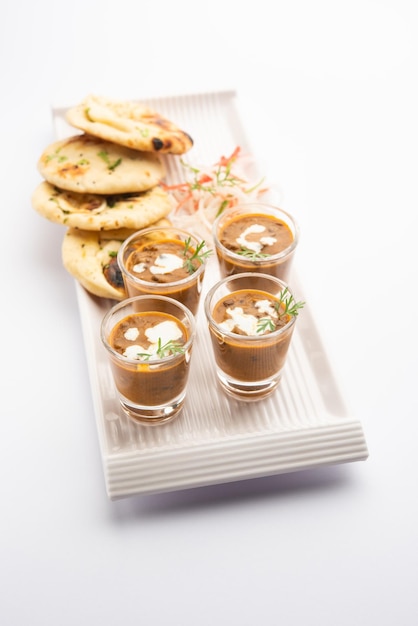 Dal Makhani oder Dal Makhni Shots mit Naan Kidneybohnen Butter und Sahne, serviert mit Knoblauch-Naan oder indischem Brot oder Roti