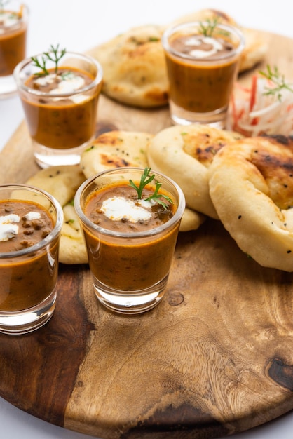Dal Makhani oder Dal Makhni Shots mit Naan Kidneybohnen Butter und Sahne, serviert mit Knoblauch-Naan oder indischem Brot oder Roti