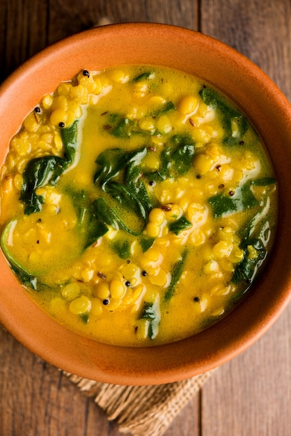 Dal Palak ou caril de espinafre de lentilha - receita saudável do prato principal indiano popular. servido em um karahi ou panela ou tigela. foco seletivo