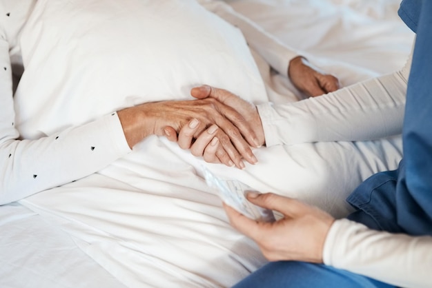 Dale tu mano a alguien y le darás esperanza Captura recortada de una enfermera de la mano de una anciana