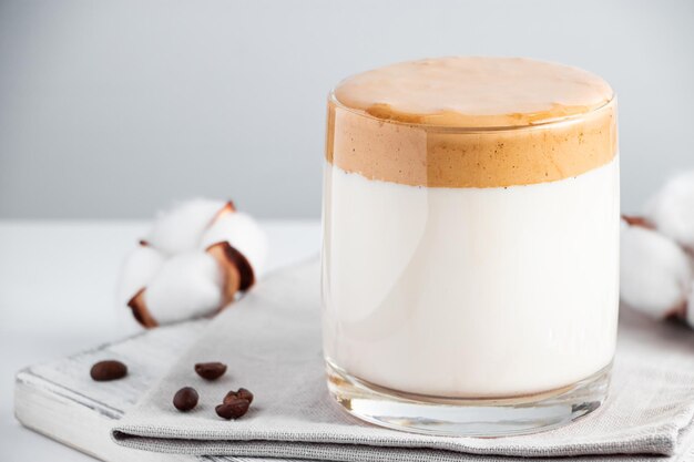 Dalgona-Eiskaffee Ein Glas trendiges, fluffiges Getränk aus Milch und Schlagsahne