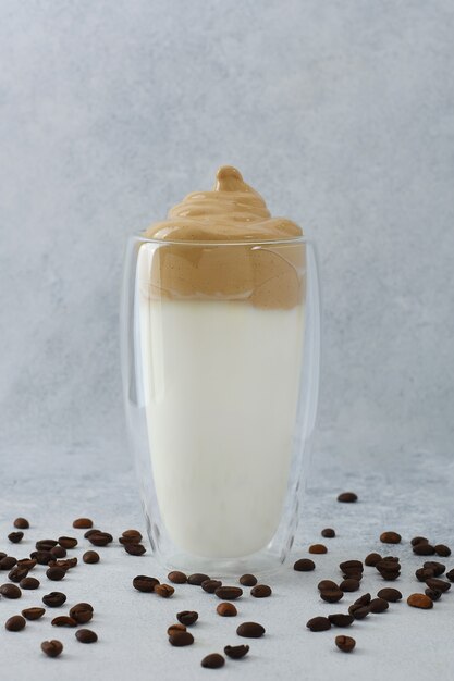 Dalgona Kaffee geschlagener Kaffee im hohen Glas mit Kaffeebohnen herum