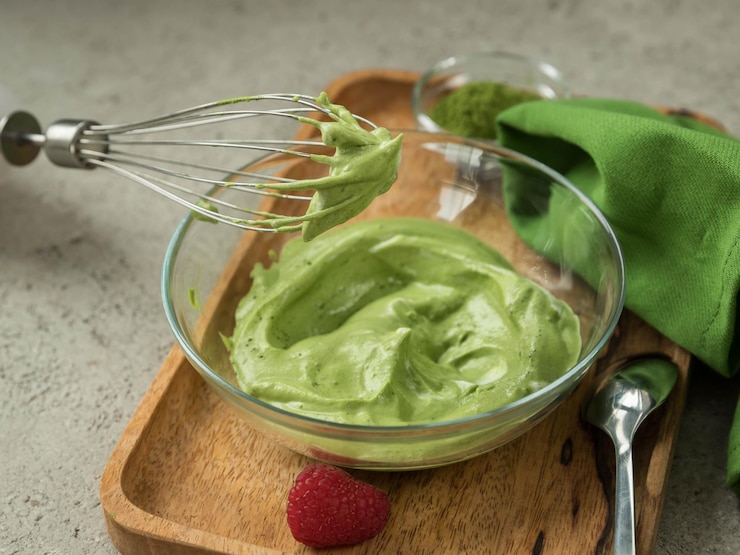Foto dalgona matcha creme em uma tigela bata guardanapo verde em um fundo cinza bebida na moda