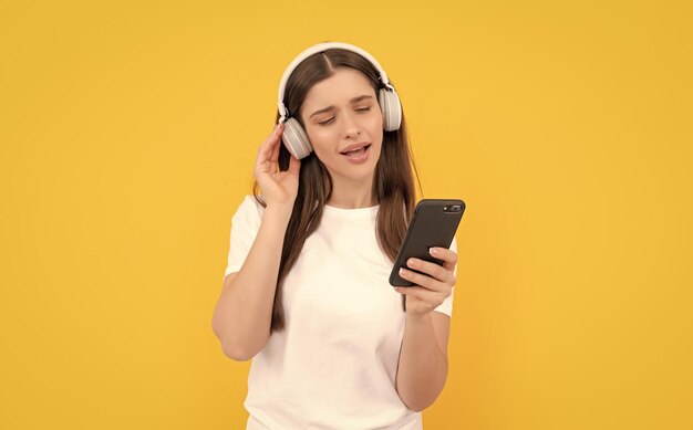 Dama con camisa blanca cantando en auriculares y charlando sobre tecnología telefónica