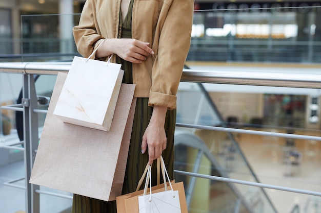 Dama de chaqueta con bolsas de compras