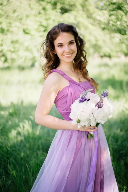 Dama de honor con un lujoso y colorido ramo de bodas de peonías y otras flores de pie en la ceremonia