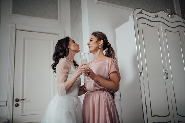 Foto la dama de honor y la novia con la flauta de champán