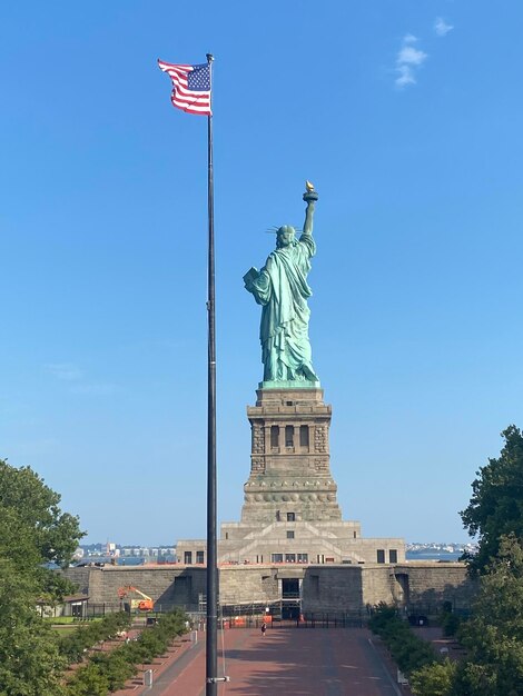 La Dama de la Libertad respaldada por la bandera estadounidense