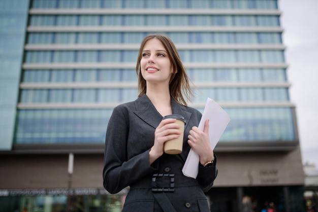 La dama de negocios se para frente al centro de negocios