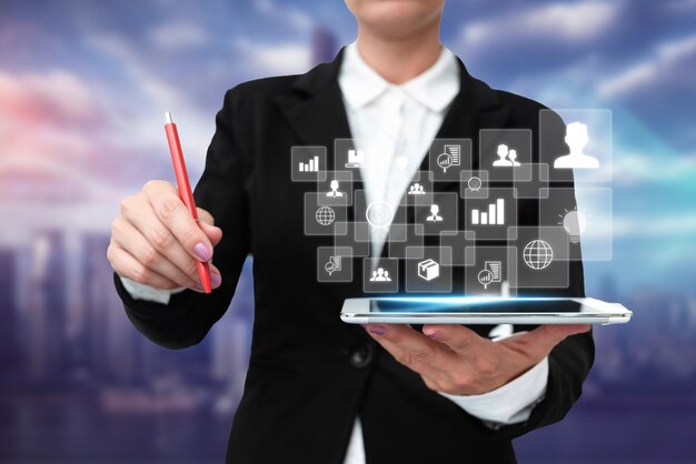 Foto dama en uniforme de pie sosteniendo tableta y virtualmente escribiendo con pluma mujer de negocios cargando pad escribiendo y mostrando nuevas tecnologías futuristas