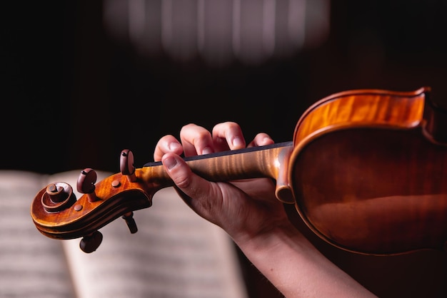 Las damas estudian música clásica en violín con los dedos delante de la partitura.