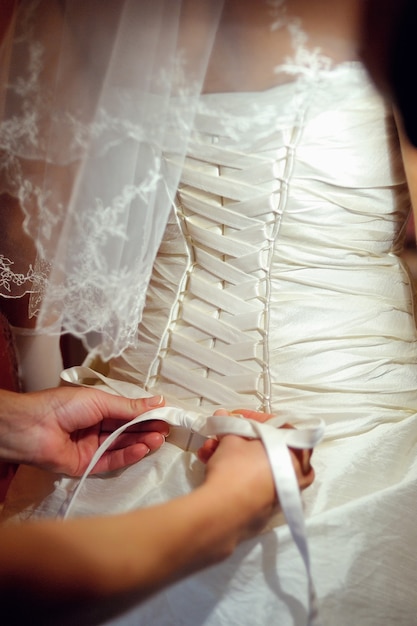 Foto damas de honor ayudando a la novia a llevar un vestido de novia.