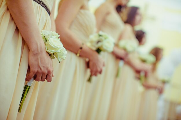 Damas de honor de una boda con flores en la mano