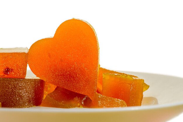Foto damasco de geléia de frutas cristalizadas em forma de coração em fundo isolado