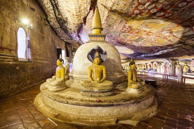 Foto dambulla, sri lanka - 17 de fevereiro de 2017: stupa ou dagoba e estátuas de buda dentro do templo da caverna de dambulla. cave temple é um patrimônio mundial perto da cidade de dambulla, sri lanka.