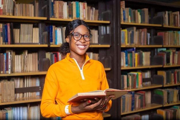 Dame, die lächelnd in der Bibliothek liest