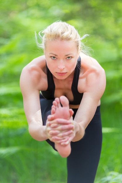 Foto dame, die yoga in der natur praktiziert.