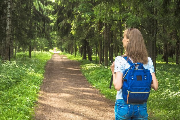 Dame mit Rucksackreise in den Wald.