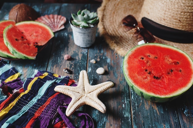 Foto damen- oder mädchenmode-accessoires für die strandsaison mit reifen wassermelonen-seesternen und topfpflanzen