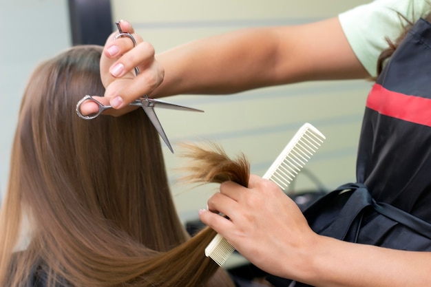 Damenfriseur, Schönheitssalon. Professioneller Stylist schneidet weibliches Haar im Salon