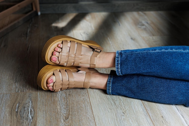 Damensandalen Nahaufnahme weiblicher Füße in lässigen braunen Sandalen Kollektion von Sommer-Damensandalen