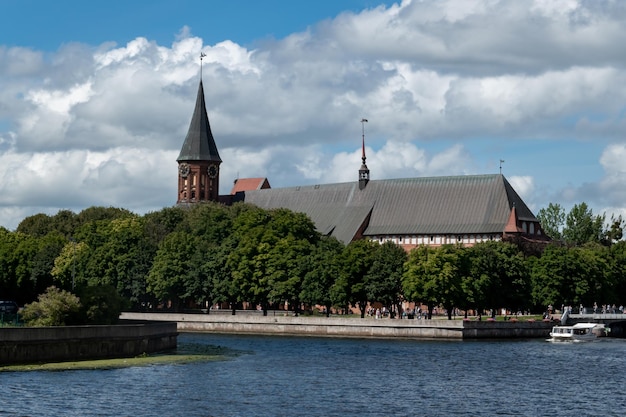 Damm des Flusses Pregol mit Blick auf die Insel Kant in der Stadt Kaliningrad Russland Kalingrad Keninsberg Sommertourismus in Russland Boot auf dem Wasser Baltika Kant Jubiläum von Kant