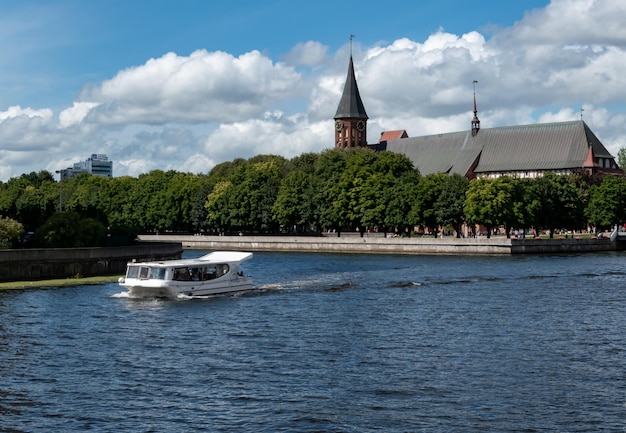 Damm des Flusses Pregol mit Blick auf die Insel Kant in der Stadt Kaliningrad Russland Kalingrad Keninsberg Sommertourismus in Russland Boot auf dem Wasser Baltika Kant Jubiläum von Kant