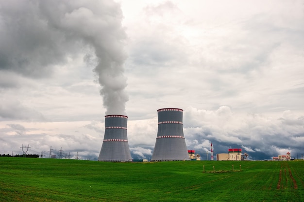 Dampfende Kühltürme des Kernkraftwerks gegen den bewölkten dramatischen Himmel in Ostrovets, Region Grodno, Weißrussland.