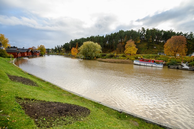 Dampfer, Longboat am Pier. Herbstliche Landschaft.