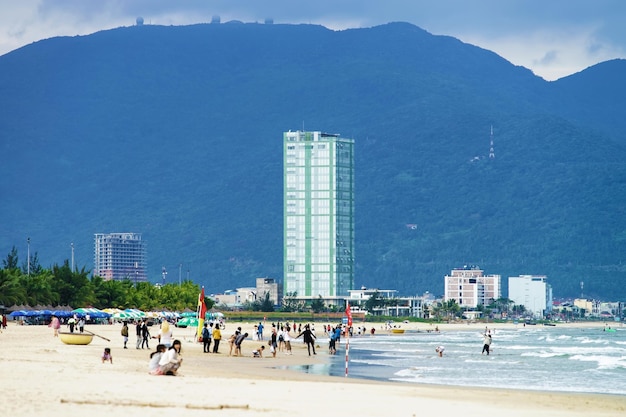 Danang, Vietnam - 20 de febrero de 2016: Turistas caminando en la playa de China en Danang en Vietnam. También se la llama Playa Non Nuoc. Mar de China Meridional en el fondo.