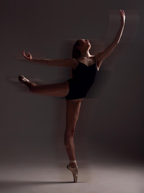 Foto dança de flexibilidade e mulher no escuro para balé isolado em um fundo preto em um estúdio criativo elegante e dançarino dançando para um ensaio de performance de teatro ou movimento de bailarina