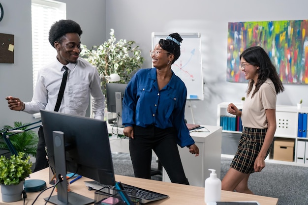 Dança no escritório de trabalho pausa da festa da empresa duas garotas e um homem de camisa e gravata