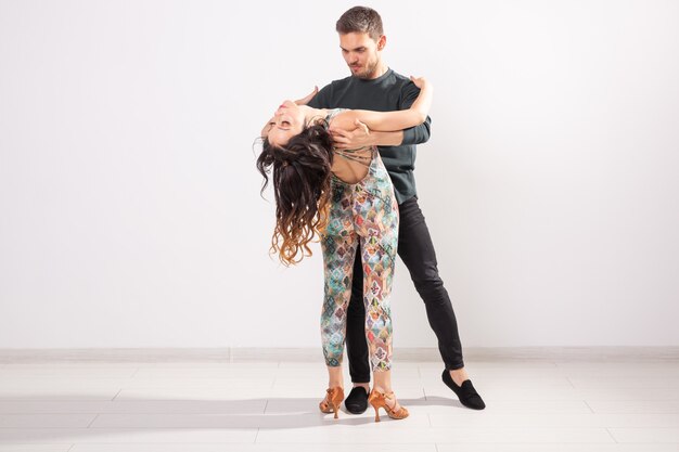 Dança social, bachata, kizomba, tango, salsa, conceito de pessoas - jovem casal dançando sobre fundo branco com espaço de cópia