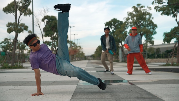 Foto dançarina atraente faz break dance na frente de um amigo animado