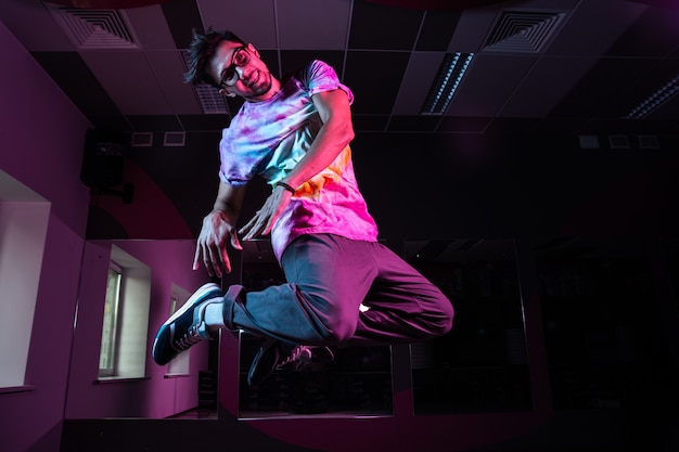 Dançarina break profissional em movimento, praticando a dança hip-hop moderna em luz de néon rosa