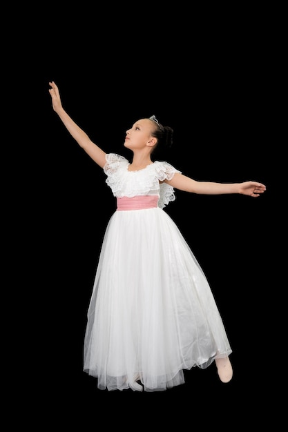 Dançarina de balé de menina em vestido longo branco dança teatral fundo preto Foto de estúdio de corpo inteiro