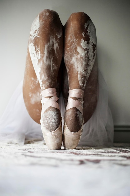 Foto dançarina de ballet com sapatos de ponta em equilíbrio manchados de pó branco