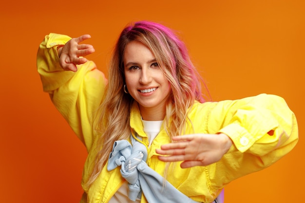 Dançarina de mulher moderna e elegante posando contra fundo amarelo