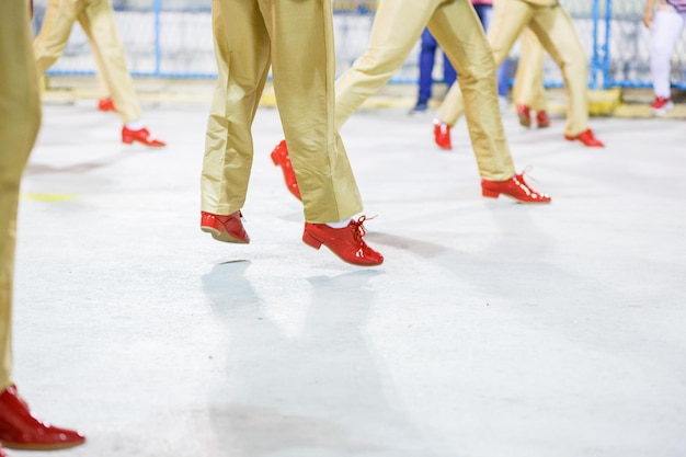 Dançarina de samba com calça cor de areia e sapato vermelho se apresentando no Rio de Janeiro