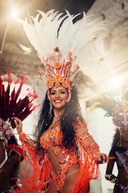 Dançarina e retrato em carnaval sorriso e desempenho com coroa de penas para a cultura Pessoa feliz e traje com talento arte e tradição para celebração entusiasmado e boate no Brasil