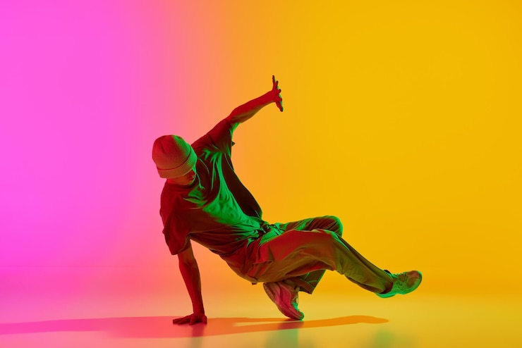 Foto dançarina talentosa vestida de rua executando movimentos de freestyle em movimento em luz de néon contra