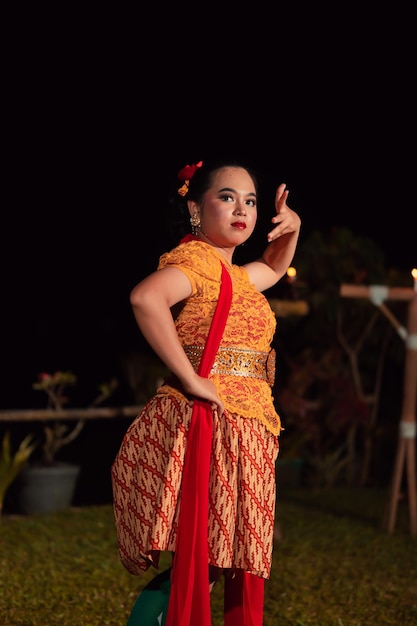 Dançarinos balineses em trajes tradicionais de cor amarela apresentam a dança na frente dos visitantes em Bali